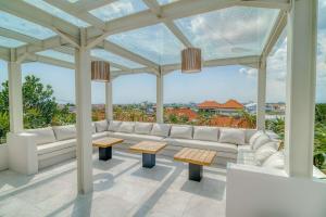 a pergola with a couch and tables on a patio at Coco Lifestyle Residence in Canggu