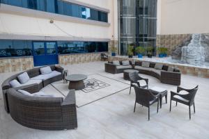 a courtyard with couches and tables and chairs in a building at THE PARK HOTEL Formerly Al Jawhara Gardens in Dubai