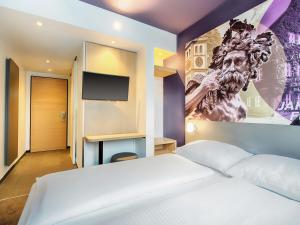 a bedroom with a white bed and a painting on the wall at B&B Hotel Augsburg-West in Augsburg