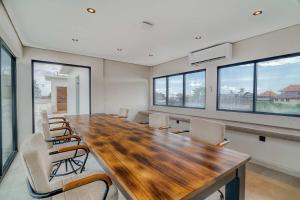 a conference room with a large wooden table and chairs at Coco Lifestyle Residence in Canggu