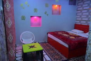 a small bedroom with a bed and a table at Shri Ram Lala Palace in Jāmb