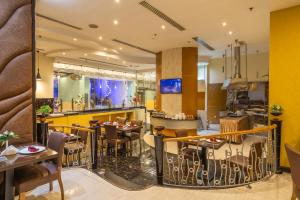 a restaurant with tables and chairs and a bar at THE PARK HOTEL Formerly Al Jawhara Gardens in Dubai +42 photos