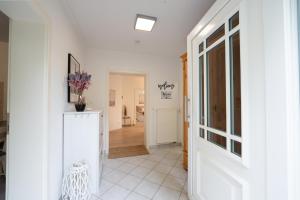 a hallway with white walls and a white floor at Moderne FeWo "Waldgeflüster" mit großzügiger Sonnenterrasse, Strandkorb, Weber-Grill und Garten, Nähe Koblenz, Festung Ehrenbreitstein, Burgen, Bad Ems, Montabaur, Lahnstein, Wandern, Radfahren  +61 photos