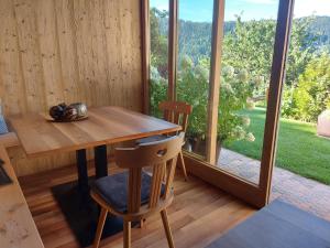 a wooden table and chairs in a room with a large window at Alpenrose in Meltina