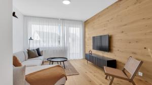 a living room with a couch and a tv at Meadows Terraced Houses in Loučná pod Klínovcem