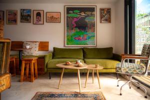 a living room with a green couch and a table at Casa Del Sonder in Cape Town