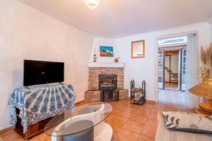 ein Wohnzimmer mit Kamin und Fernseher in der Unterkunft Les Pieds dans l'Aude in Cuxac-dʼAude