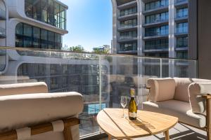 a balcony with a table and a bottle of wine at Mercury Suite Designer Apartment with Pool Access in St. Julianʼs