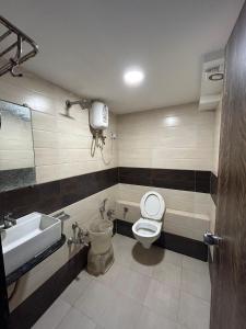 a bathroom with a toilet and a sink at Hotel Pathik in Ahmedabad