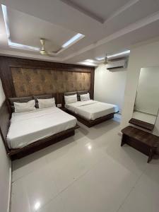 two beds in a room with two beds sidx sidx sidx sidx sidx at Hotel Pathik in Ahmedabad