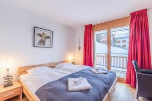 a bedroom with a bed and a window with red curtains at Ski Paradise SP 009 - MOUNTAIN apartment 4 pers in Veysonnaz