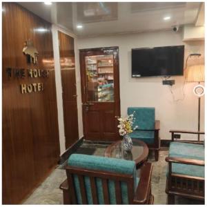 a living room with a table and chairs and a tv at The House Hotel Darjeeling in Darjeeling