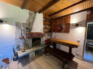 a living room with a fireplace and a bench at Casa nei boschi della Val Bormida in Calizzano