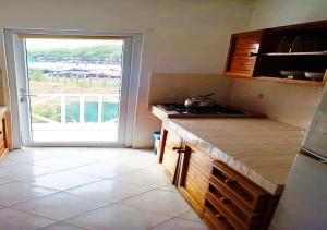 a kitchen with a counter and a window with a view at appartement lagon blue in Mahébourg