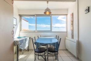 a dining room with a blue table and chairs at Les Balcons de la Méditerranée in Narbonne-Plage