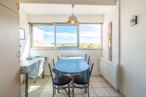 a dining room with a blue table and chairs at Les Balcons de la Méditerranée in Narbonne-Plage +13 photos