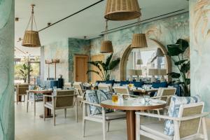 un ristorante con tavoli e sedie e un murale di Mercury Suite Designer Apartment with Pool Access a San Giuliano
