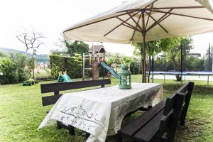 - une table avec un parasol à côté d'une aire de jeux dans l'établissement B&B LA CORTE SANTA MARIA, à Negrar