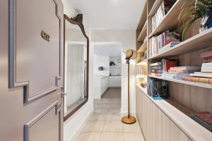 ein Flur mit einer Tür und einem Regal mit Büchern in der Unterkunft Waterfront Premium Apartment in central Geelong in Geelong