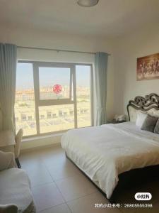 a bedroom with a bed and a large window at 同鑫青旅 in Ajman 