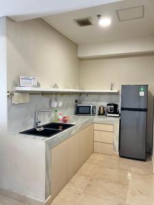 eine Küche mit Spüle und Kühlschrank in der Unterkunft Podomoro Delipark Apartemen Cozystay Empire Tower 3BR Medan in Medan