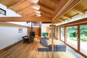 a living room with wooden ceilings and a blue couch at 箱根こもれび庵 in Hakone +68 photos