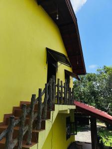 a yellow building with a staircase and a window at Dean House in Hikkaduwa