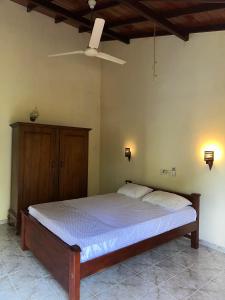 a bedroom with a bed and a ceiling fan at Dean House in Hikkaduwa