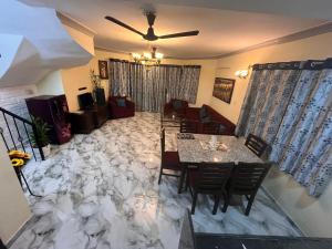 a living room with a marble floor with a table and chairs at Enclave Villa 4BHK in Lonavala