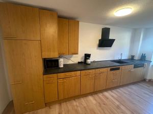 a kitchen with wooden cabinets and a microwave at Vöhrenbach 1 in Vöhrenbach