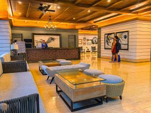 a woman standing in a lobby with a table and chairs at Condo in Tagaytay - AB Residences in Tagaytay