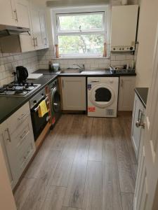 a kitchen with a sink and a washing machine at Newly amazing refurbished two bedroom apartment in Harrow on the Hill