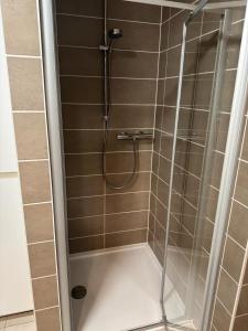 een douche met een glazen deur in een badkamer bij MeretMoi -- Modern appartement in Oostende in Oostende