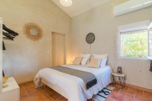 a bedroom with a white bed with a window at Domaine Plan Des Devens Tendresse in Roussillon