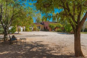 a park with a bench next to a tree at Domaine Plan Des Devens Tendresse in Roussillon
