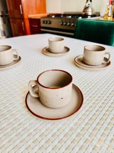 three cups and saucers sitting on a table at VIP Karatal 4k City Plus Wi-Fi, Smart TV in Taldykorgan +5 photos