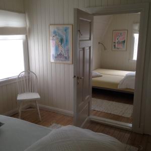 Un dormitorio con una cama, una silla y un espejo. en Linddalsveien 7, 4950 Risør, Norway, en Risør