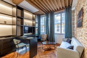 a living room with a couch and a table at SWEET LEONE II -appartement avec spa privé-Lyon Place Terreaux in Lyon