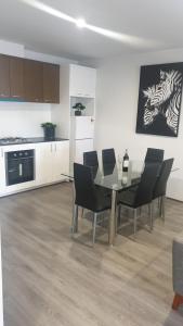 a dining room with a glass table and chairs at Smart, stylish apartments built for easy living in Kelmscott