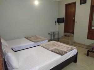 DargaiにあるHotel Classic Innのドア付きの部屋にベッド2台が備わります。