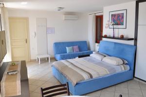 a bedroom with a blue bed and a blue couch at Apartments & Rooms Riva in Piran