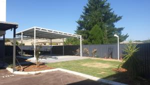 a metal pavilion in a yard with a fence at Nice 2 bedroom apartment in Kelmscott