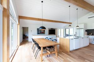 a kitchen and dining room with a wooden table and chairs at By the river - Le 91 in Frelighsburg
