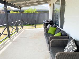 a covered patio with couches and a railing at Sea Breeze in Lancelin
