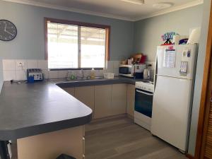 a kitchen with a white refrigerator and a sink at Sea Breeze in Lancelin