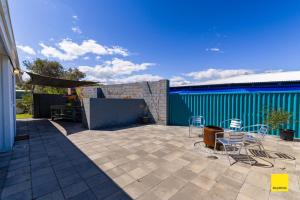 a patio with chairs and tables and a building at Sea Gem in Lancelin