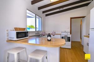 a kitchen with a counter with two glasses of wine at Sea Gem in Lancelin