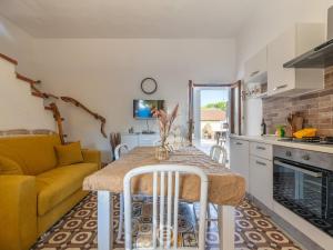 La Casa sul Mare في San Vero Milis: مطبخ وغرفة معيشة مع طاولة وأريكة صفراء