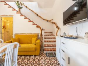 La Casa sul Mare في San Vero Milis: غرفة معيشة مع كرسي أصفر ودرج