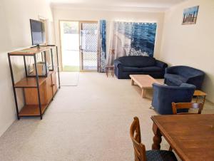 a living room with a couch and a table at Aqua Sands Chalets in Lancelin